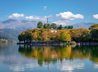 View of lake Pamvotis and the waterfront of the city of Ioannina, Greece, with the Old Castle and the Aslan Pasha Mosque. Reflections on the water in the autumn.