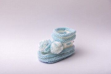 homemade knitted shoes for newborn boys on white background