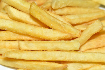 Juicy yellow delicious fries on a white plate