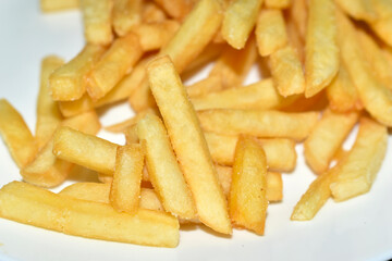 Juicy yellow delicious fries on a white plate