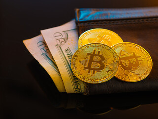 American dollars in a brown leather wallet and the world-wide popular cryptocurrency - bitcoins. Virtual and real money, sale, purchase, currency exchange. New financial opportunities.