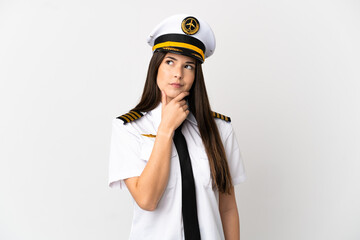 Brazilian girl Airplane pilot over isolated white background having doubts and with confuse face expression © luismolinero