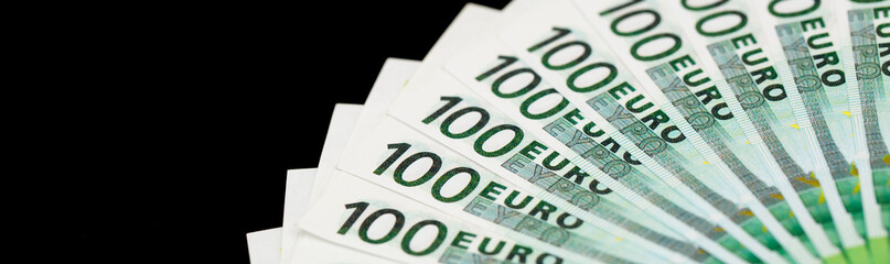 Banknotes of 100 euros are beautifully laid out on a black background. One hundred euro money.