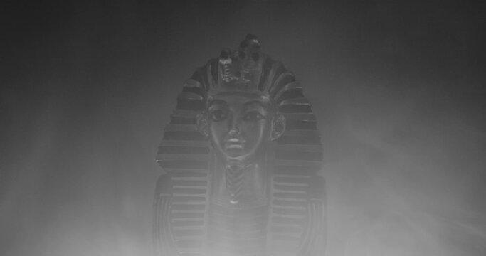 Statue of King Tut with flickering light and smoke