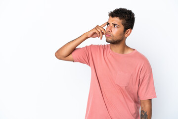Young handsome Brazilian man isolated on white background making the gesture of madness putting...