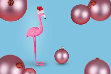 Foto op Canvas Winter flamingo in Santa hat and flying Christmas bauble balls. Merry Christmas and Happy New Year greeting card. © Jovica Varga