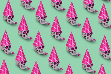 Pattern of human skull  with a pink birthday cap and whistle on a green background. Minimal holiday...