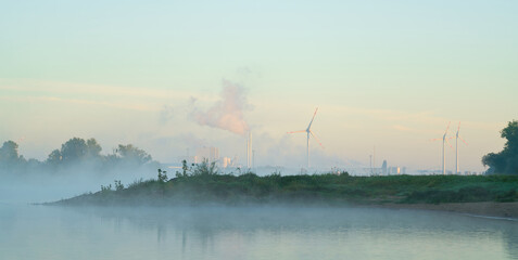 Fototapeta na wymiar Industriegebiet Rothensee am Ufer des Flusses Elbe bei Nebel vom Herrenkrugpark gesehen