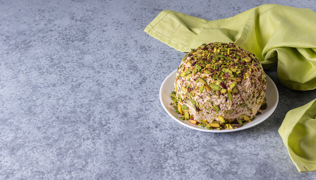 Sesame halva with nuts and green napkin on gray background