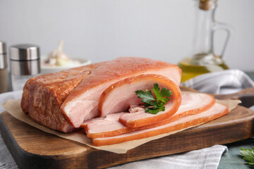 Delicious smoked bacon with parsley on table, closeup