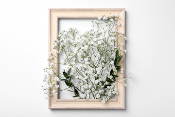 Wooden frame with beautiful gypsophila flowers and eucalyptus branches on white background
