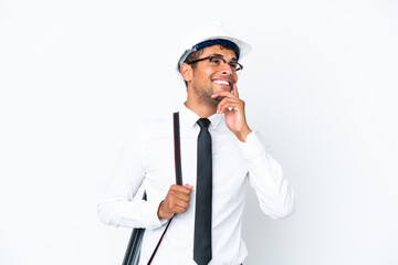 Architect brazilian man with helmet and holding blueprints thinking an idea while looking up