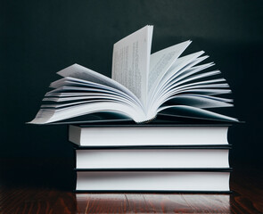 Books on a brown table in a bookstore. Black background. 