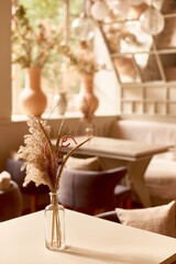 transparent glass vase on table in cafe. mockup design interior.shallow depth of field vertical photo