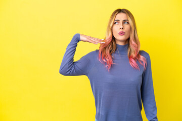 Fototapeta premium Young woman over isolated yellow background with tired and sick expression