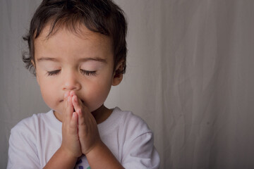 portrait of little boy praying to his god