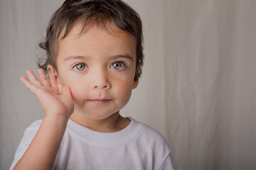 portrait of little boy raising his hand