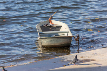 Naklejka premium Small wooden boat in the water at the pier