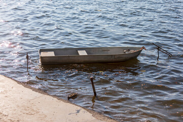 Obraz premium Small wooden boat in the water at the pier