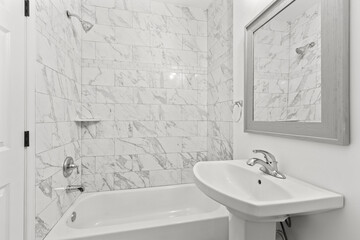 marble bathroom with sink and tub shower