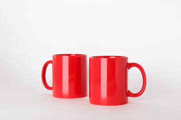 Blank red ceramic mugs on light background