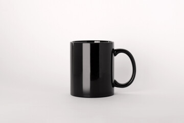Blank black ceramic mug on light background