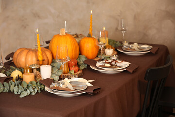 Beautiful autumn place setting and decor on table in room