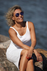 young woman by the sea in a white dress