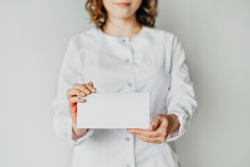 a girl doctor or cosmetologist holds a box of medicines or a cosmetic preparation in her hands. A place for the inscription on the box.