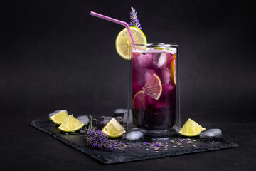 Fresh homemade lemonade with lavender and ice. Delicious purple icy cold party drink on slate board...