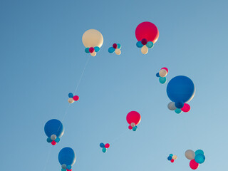 Large white and orange balloons fly in the sky