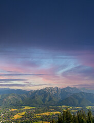 Vertical view of mountains in nature of sleeping knight tatra mountain covered with dramatic clouds aka as giewont and dramatic sunset or sunrise located in Zakopane, South Poland, Europe.