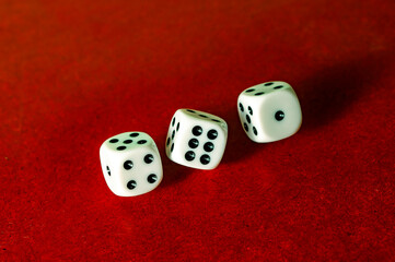 Three dices falling on a red surface.  Casino or boardgame theme.