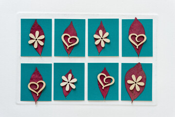 wooden heart and flower shapes on autumn leaves and paper squares