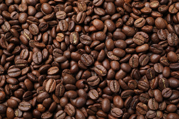 Pile of roasted coffee beans as background, top view