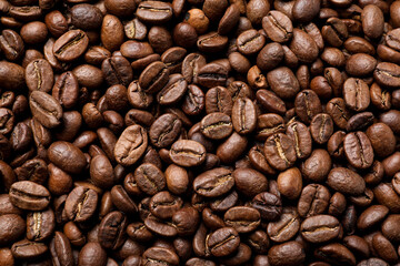 Pile of roasted coffee beans as background, top view