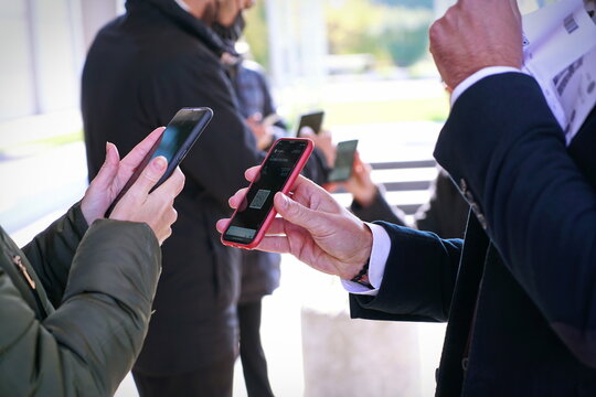 Checking the green pass on a smartphone, required for entry to an exhibition event. Selective focus.  Rimini, Italy - October 2021
