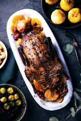 Köstlich angerichtetes Fleisch mit Beilagen auf rustikalem HIntergrund. Ente oder Gans auf einem Weihnachtstisch.