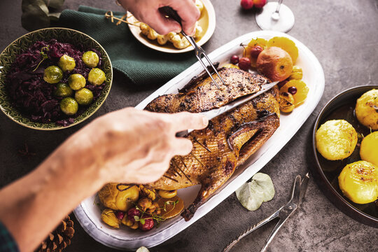 Mann schneidet k&ouml;stlich angerichtetes Fleisch f&uuml;r ein Abendessen.