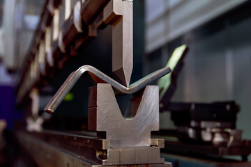 Work on a CNC bending machine in a factory. Sheet metal bending on a high-precision sheet metal...