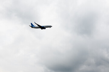 Airplane flying in gray cloudy sky