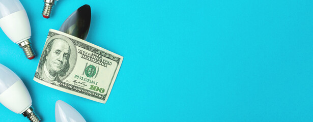 Burned out LED light bulbs and money, dollar bills. Energy savings, energy efficiency concept. Ecology problem background, top view, copy space photo