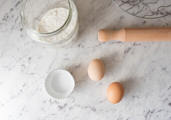 High angle view of ingredients and tools for baking on grey marbled effect background (selective...
