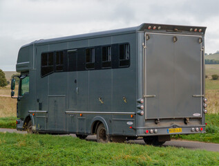 close up of a large executive grey coach-built horse transport lorry in motion across Salisbury...