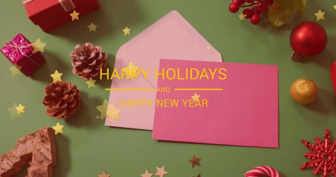 Animation of christmas greetings text over envelopes and christmas decorations