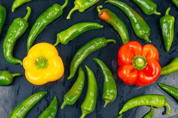 sweet and bitter hot peppers on a dark background. vitamin vegetables for health.
