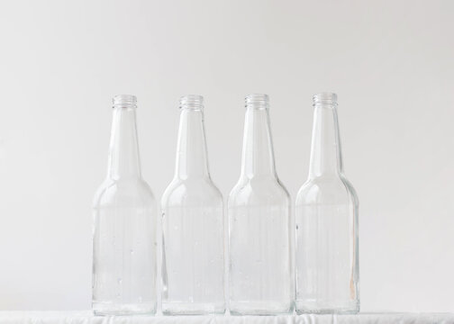 Four empty bottles on a white background. The concept of glass containers aesthetics of bottles