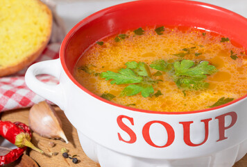 kharcho soup with greens in a white and red plate