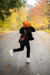 Fototapeta premium person with a pumpkin on their head dancing 
