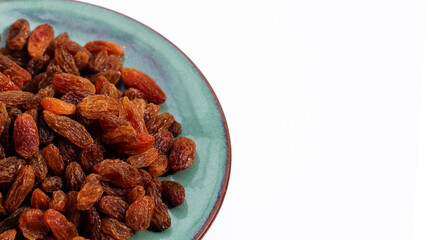 Dried grape raisins in plate on white background
